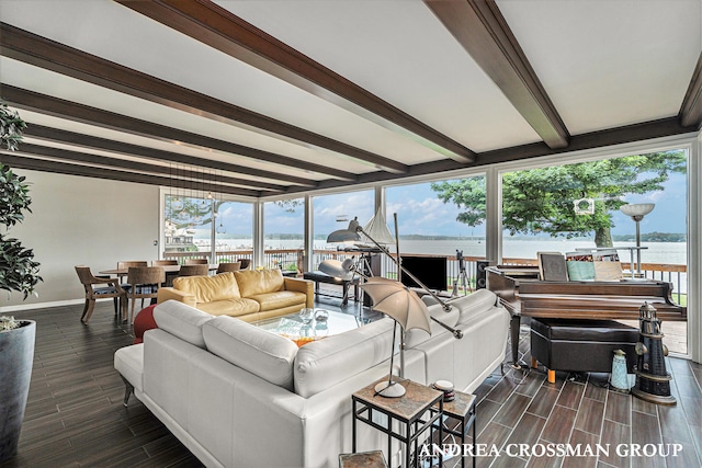 living room featuring beamed ceiling, a water view, plenty of natural light, and dark hardwood / wood-style floors