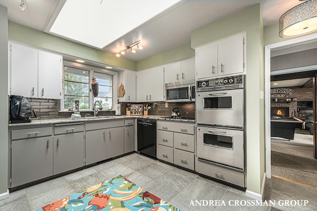 kitchen with backsplash, sink, white cabinets, and appliances with stainless steel finishes