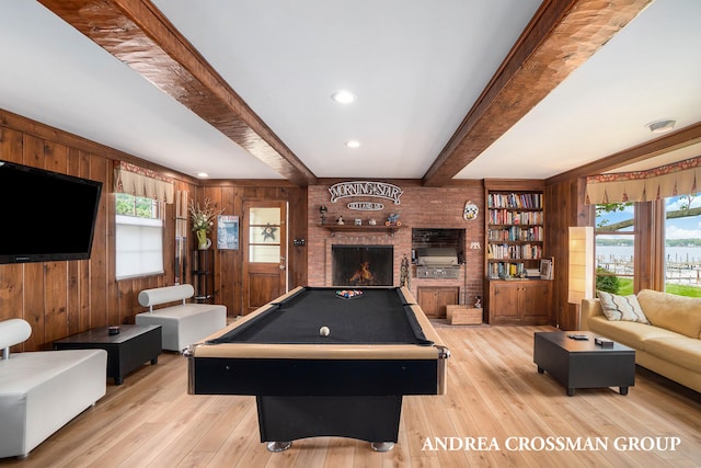 rec room with beam ceiling, a healthy amount of sunlight, and light hardwood / wood-style flooring