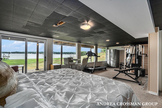 bedroom featuring carpet floors, access to exterior, stainless steel fridge, and a water view