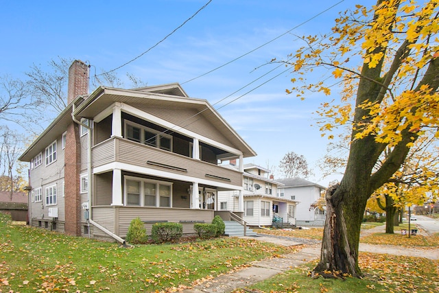 view of front facade featuring a balcony and a front lawn