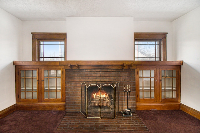 unfurnished living room with dark colored carpet, a fireplace, and a textured ceiling