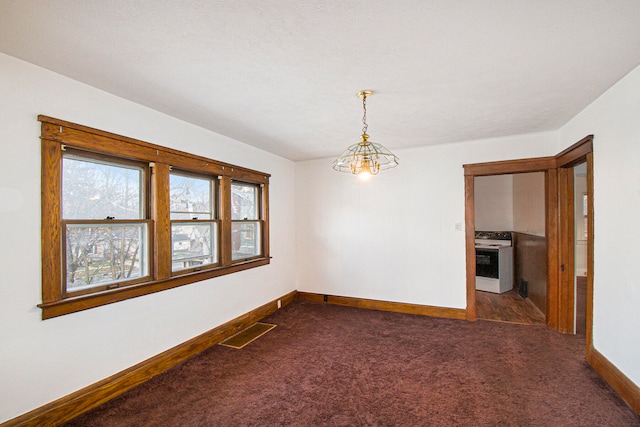 carpeted spare room featuring a notable chandelier