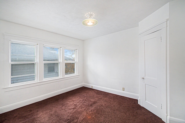 carpeted empty room with a textured ceiling