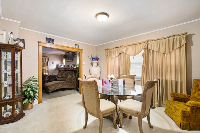 carpeted dining room with ornamental molding