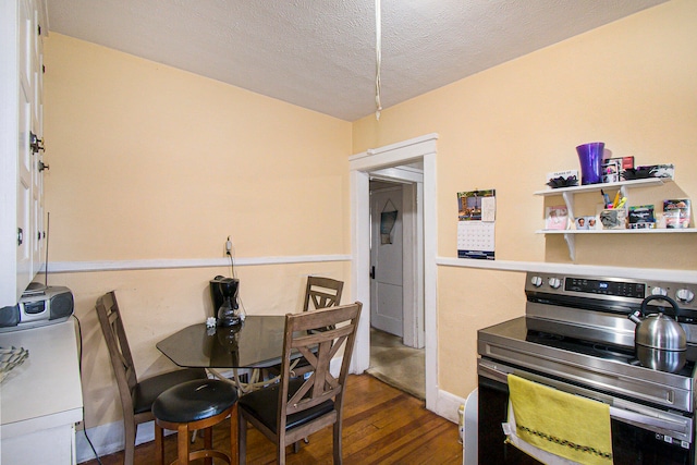 dining space with dark hardwood / wood-style flooring and a textured ceiling