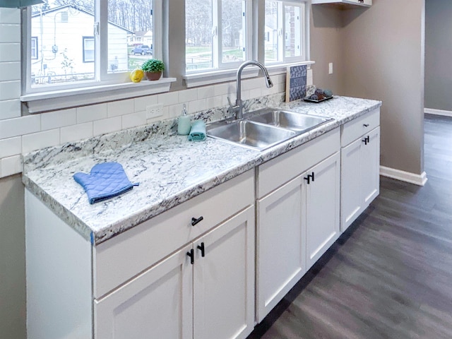 kitchen with decorative backsplash, white cabinetry, sink, and dark wood-type flooring