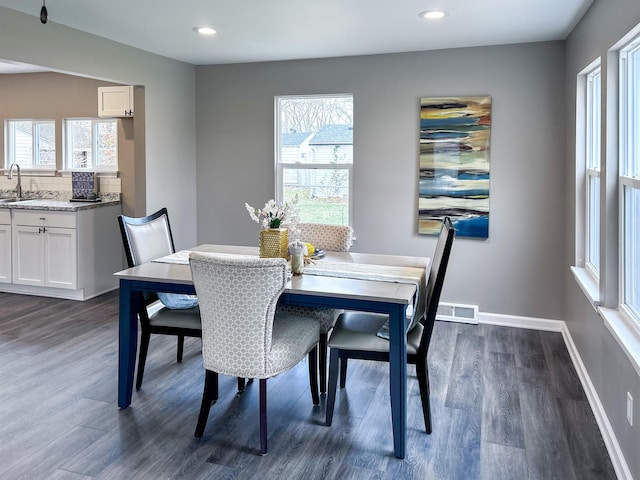 dining space with dark hardwood / wood-style floors and sink