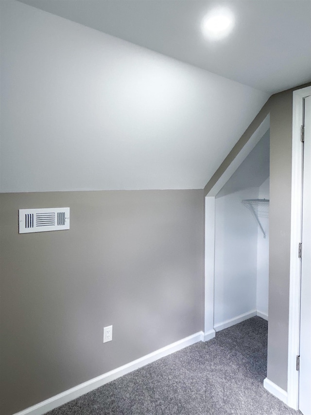 bonus room featuring dark carpet and lofted ceiling