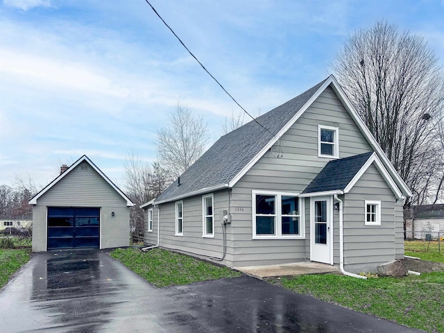 view of front of house with a garage and an outdoor structure