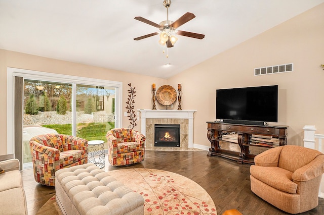 living room featuring hardwood / wood-style flooring, ceiling fan, lofted ceiling, and a fireplace