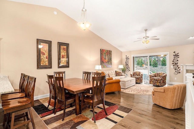 dining room with hardwood / wood-style floors, ceiling fan, and vaulted ceiling