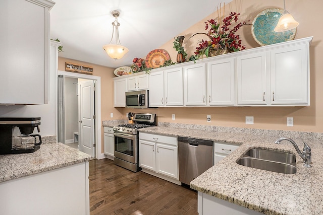 kitchen with decorative light fixtures, white cabinetry, sink, and appliances with stainless steel finishes