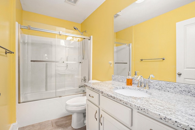 full bathroom featuring shower / bath combination with glass door, vanity, toilet, and tile patterned flooring