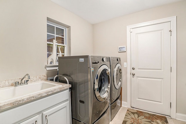 laundry area featuring cabinets, independent washer and dryer, light tile patterned floors, and sink