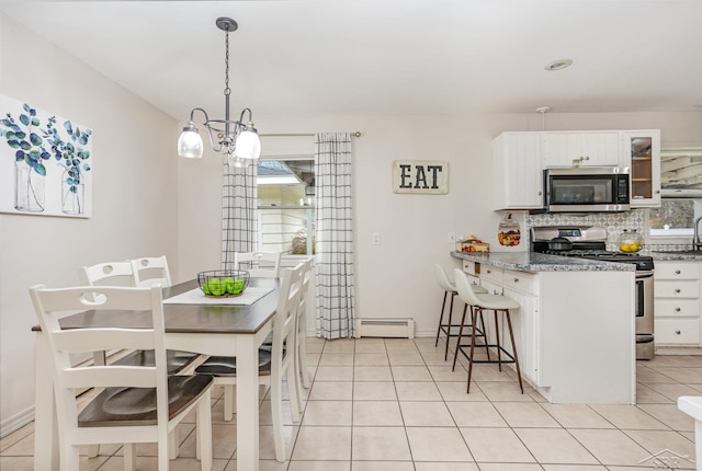 dining area with a chandelier, light tile patterned floors, and a baseboard radiator