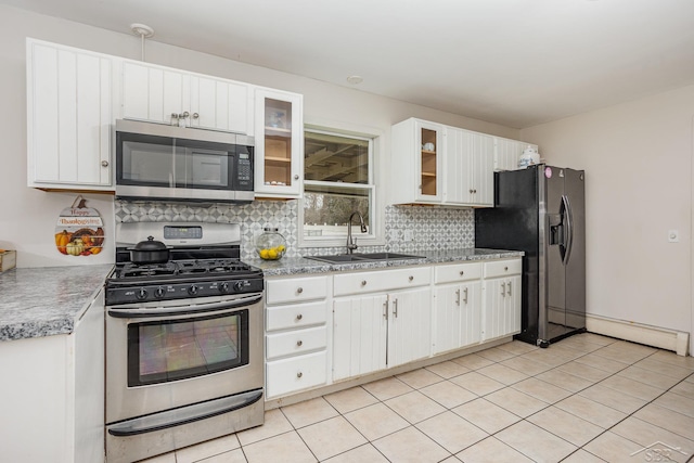 kitchen featuring sink, decorative backsplash, a baseboard radiator, white cabinetry, and stainless steel appliances