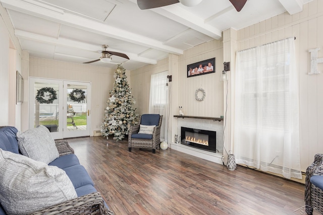 living room featuring wooden walls, beamed ceiling, and dark hardwood / wood-style floors