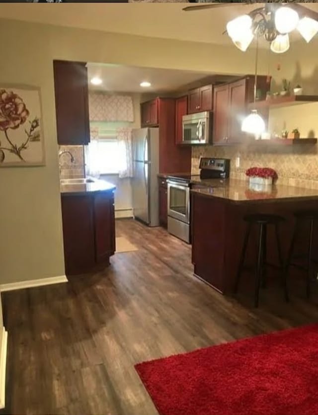 kitchen with backsplash, stainless steel appliances, ceiling fan, dark wood-type flooring, and sink