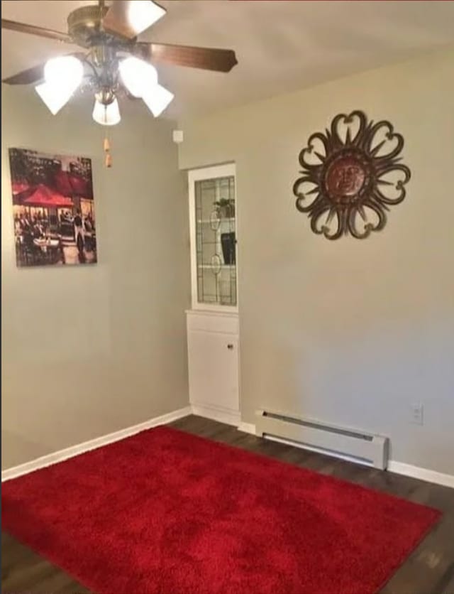 spare room with ceiling fan, dark wood-type flooring, and a baseboard radiator