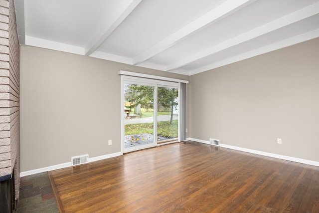 unfurnished room with beamed ceiling, dark hardwood / wood-style floors, and a brick fireplace