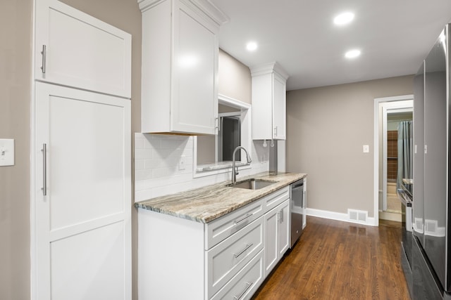 kitchen with white cabinetry, sink, light stone countertops, dark hardwood / wood-style flooring, and decorative backsplash