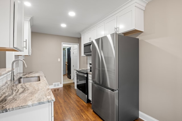 kitchen featuring light stone countertops, sink, dark hardwood / wood-style flooring, white cabinets, and appliances with stainless steel finishes