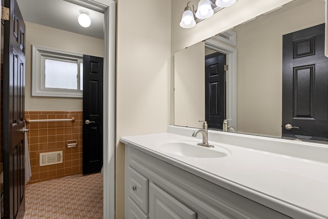 bathroom featuring tile patterned flooring, vanity, and tile walls