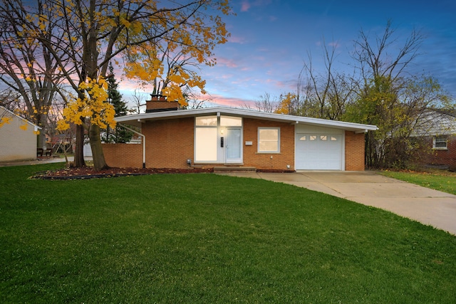 single story home with a garage and a yard