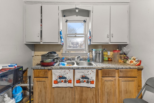 kitchen featuring backsplash, sink, and white cabinets