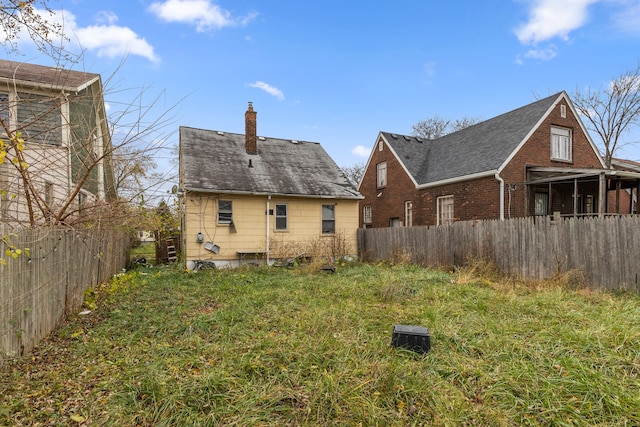 rear view of house featuring a yard