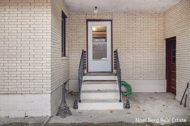 entrance to property featuring brick siding