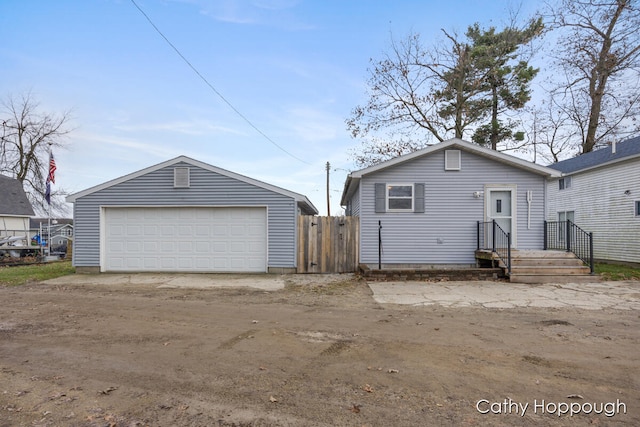 exterior space with a detached garage and an outbuilding