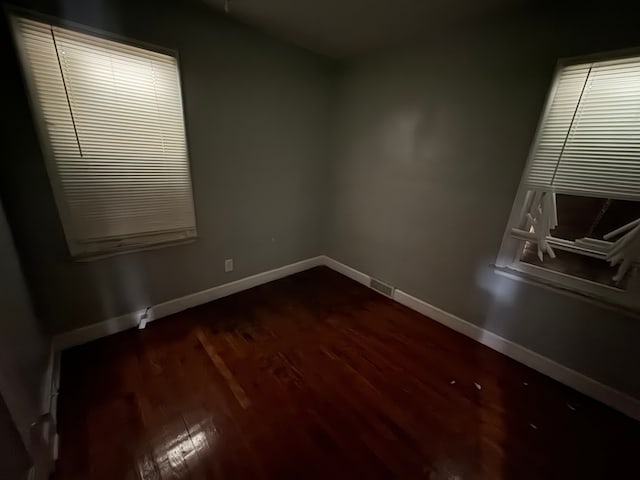 spare room with dark wood-type flooring