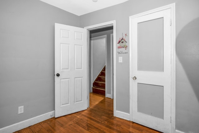 unfurnished bedroom with dark hardwood / wood-style flooring