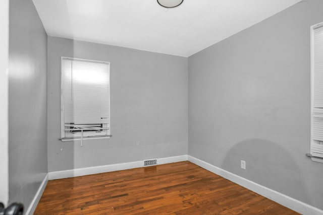 empty room with dark hardwood / wood-style flooring