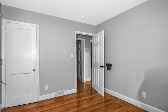 unfurnished bedroom with dark hardwood / wood-style floors