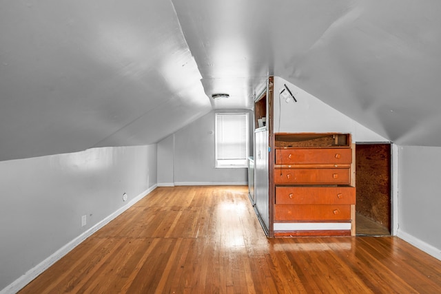 additional living space with lofted ceiling and light hardwood / wood-style flooring