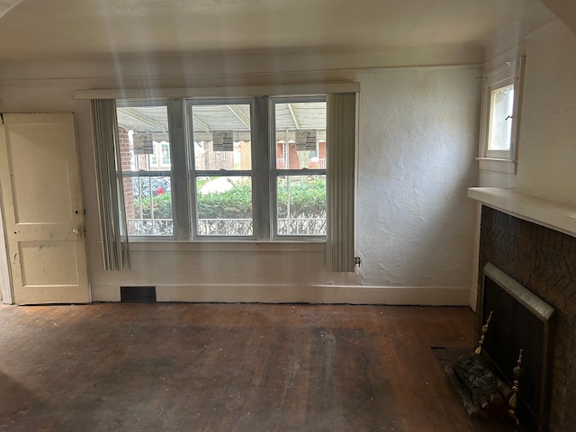 unfurnished living room with dark hardwood / wood-style flooring and a healthy amount of sunlight