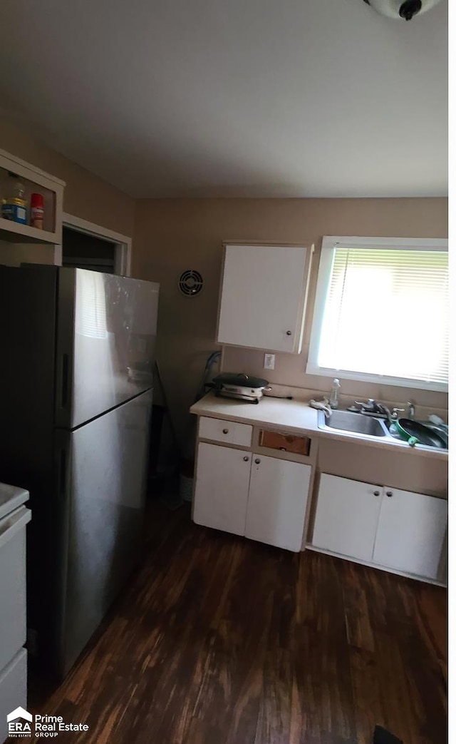 kitchen with stainless steel refrigerator, white cabinetry, dark hardwood / wood-style flooring, and sink