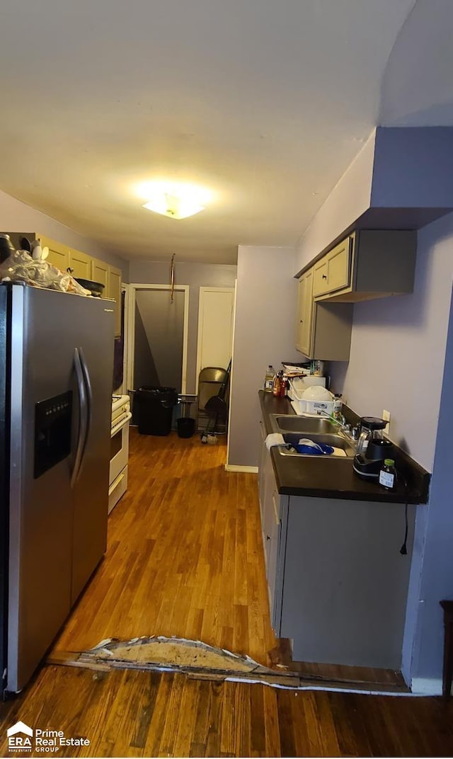 kitchen featuring gray cabinetry, sink, dark hardwood / wood-style flooring, stainless steel refrigerator with ice dispenser, and white stove