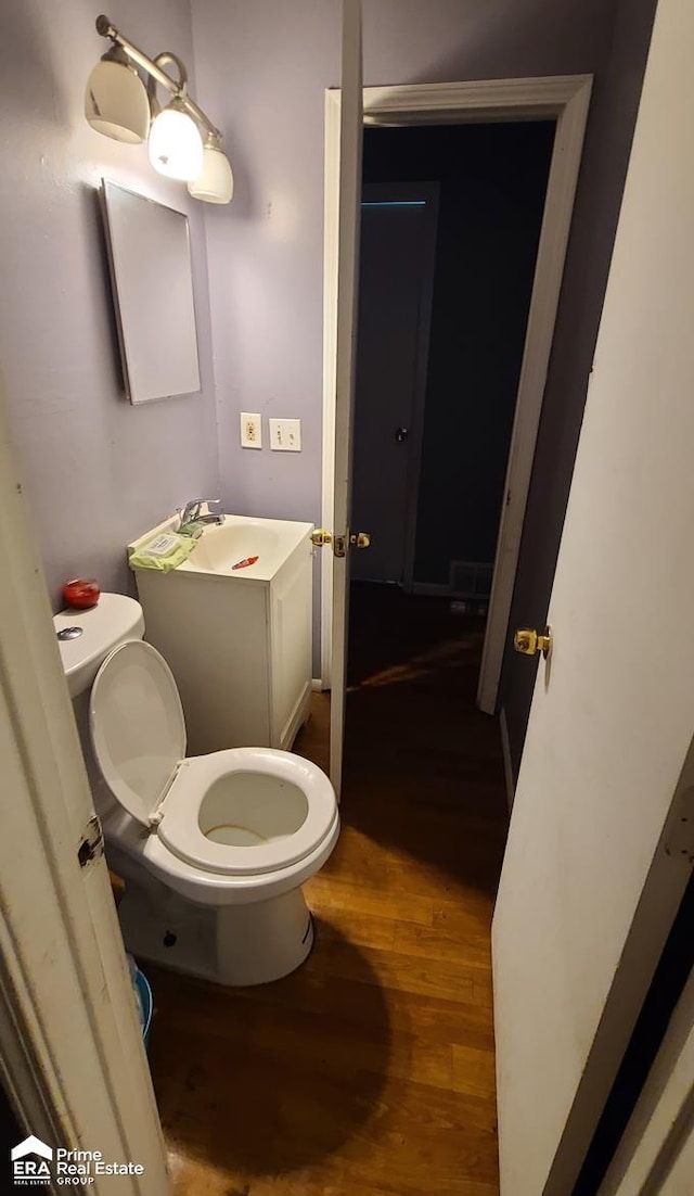 bathroom featuring vanity, wood-type flooring, and toilet