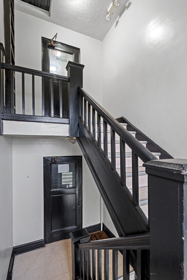 stairway with a textured ceiling