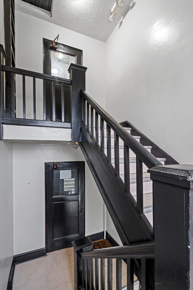 1055 Philip St, Detroit, MI 48215 - stairway featuring a textured ceiling and baseboards