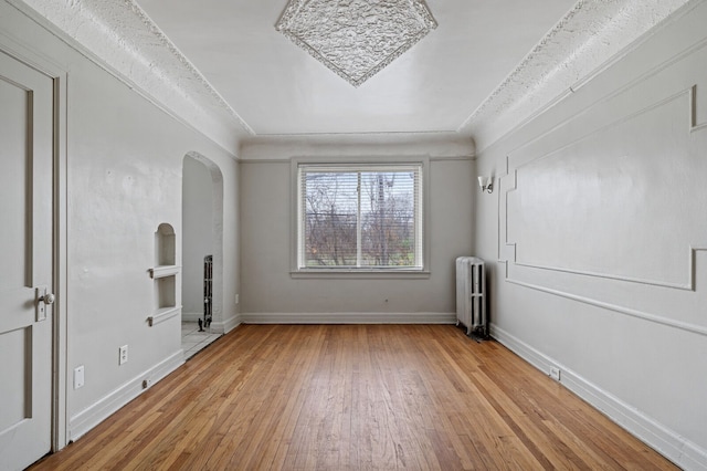 unfurnished room with radiator and light hardwood / wood-style floors