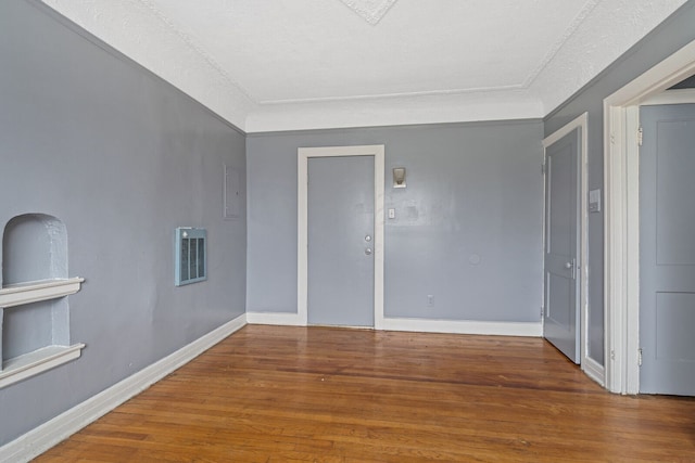 empty room with hardwood / wood-style floors and a textured ceiling