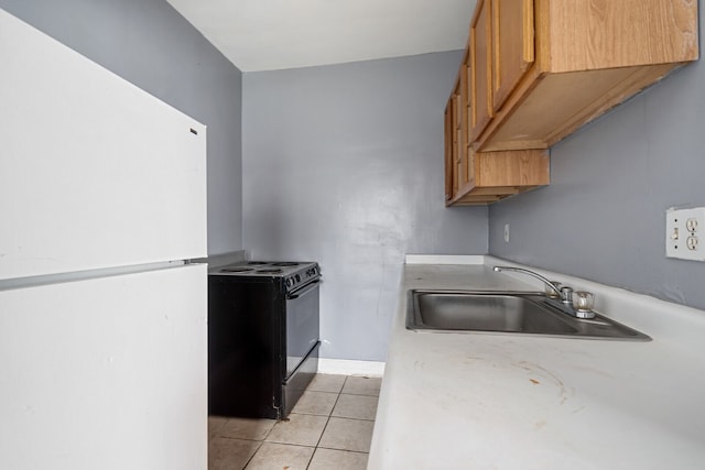 kitchen featuring black stove, white refrigerator, light tile patterned floors, and sink