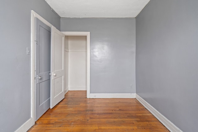 unfurnished bedroom with hardwood / wood-style floors and a textured ceiling