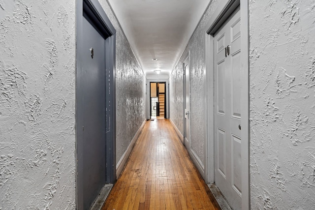 hallway with hardwood / wood-style floors