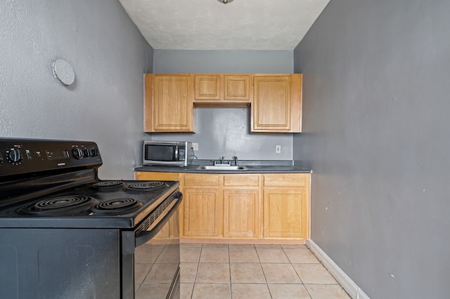 kitchen featuring sink, light tile patterned floors, stainless steel appliances, and light brown cabinetry